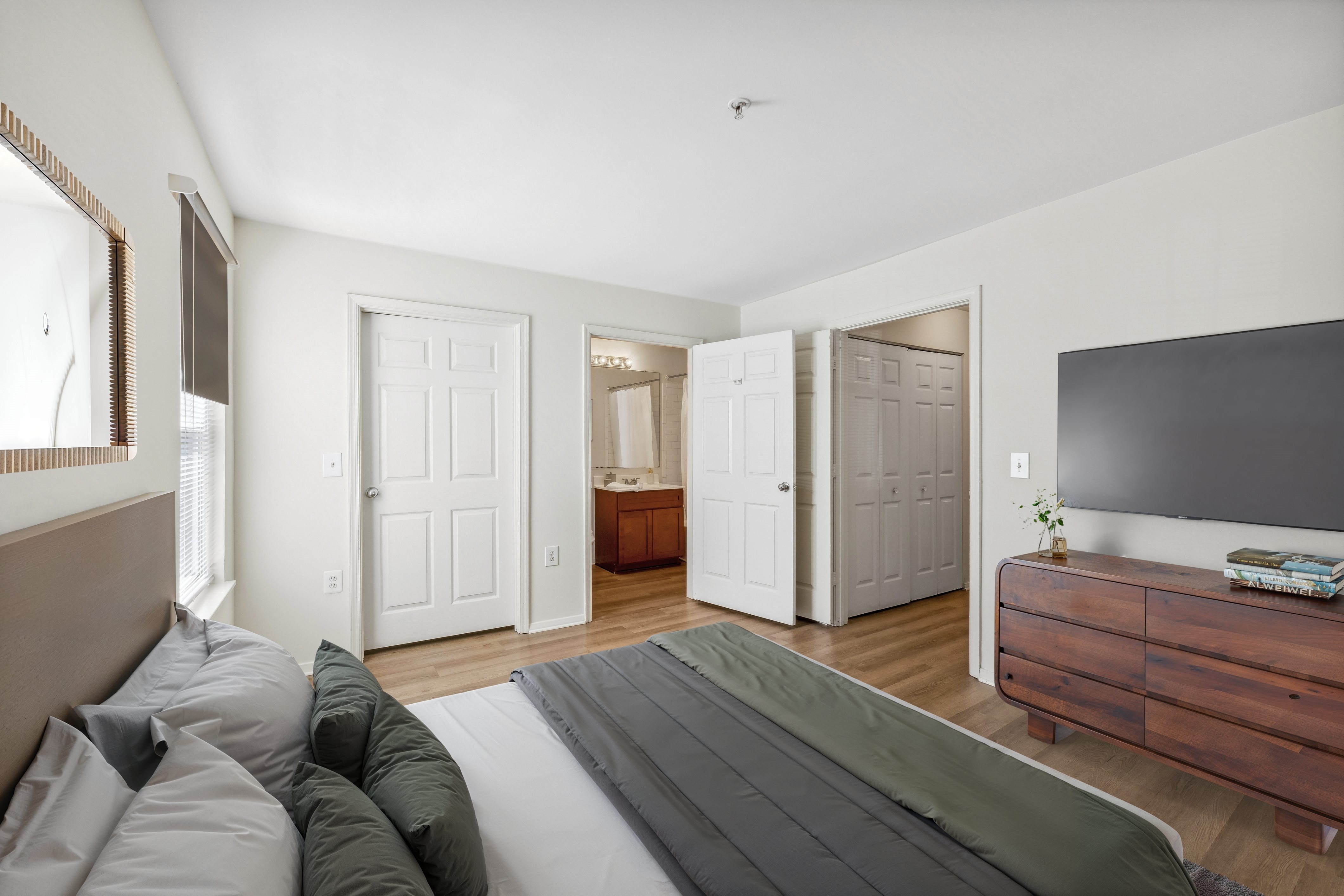 A bedroom with a bed, dresser, and mirror.